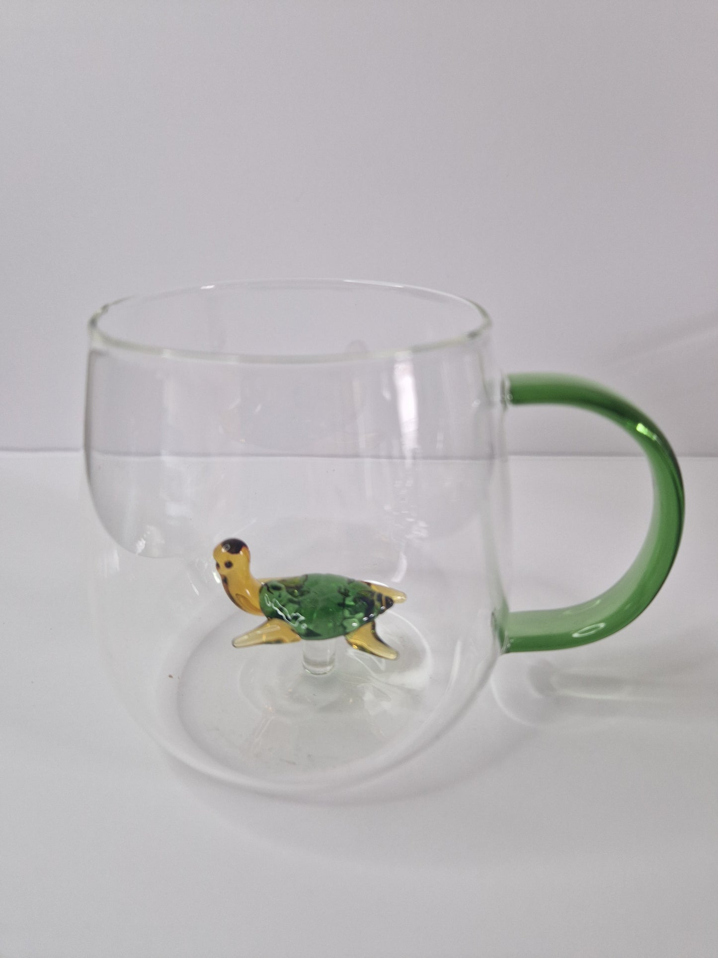 Glass coffee mugs with glass animals inside